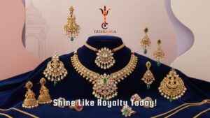 Exquisite gold and emerald bridal jewelry set by Tribhanga, including necklaces and earrings, displayed on blue velvet.