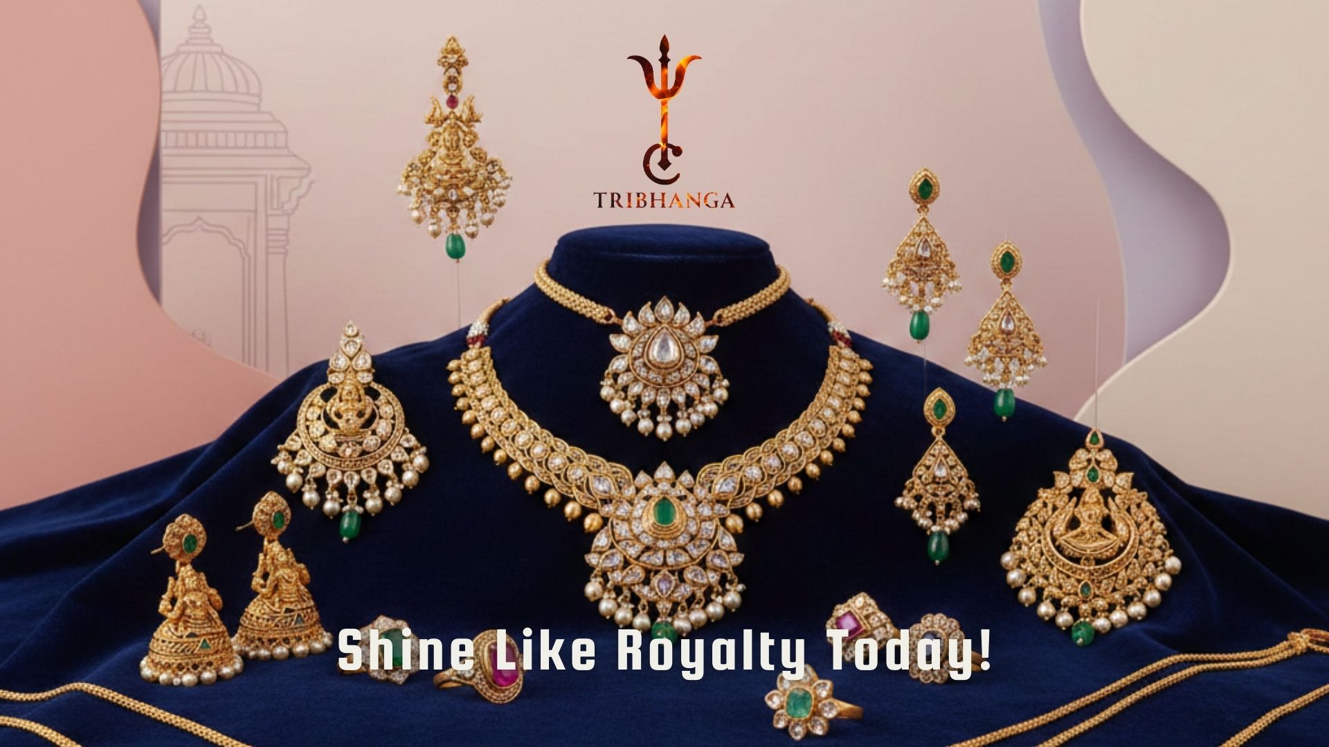 Exquisite gold and emerald bridal jewelry set by Tribhanga, including necklaces and earrings, displayed on blue velvet.