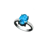 Angled view of the Tribhanga blue topaz ring showing the oval cut and setting.